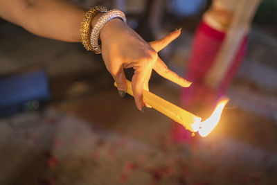 Cropped image of woman holding candle outdoors