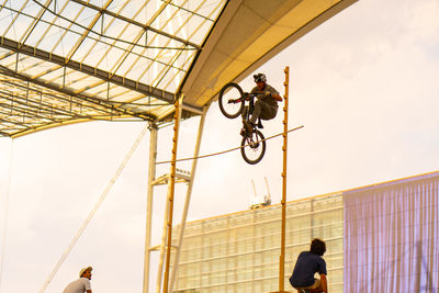 Low angle view of man riding bicycle against sky