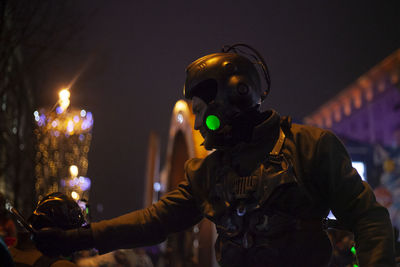 Portrait of person holding illuminated lighting equipment at night