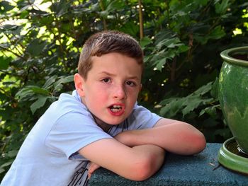 Portrait of boy leaning on retaining wall
