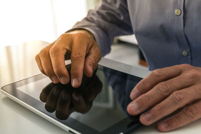 Closeup man hands typing on tablet screen. businessman using digital pad at home. office workplace