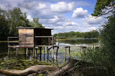 Built structure by lake against sky