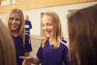 Happy blond girls talking on footpath