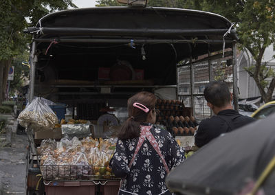 Rear view of vendors at market stall