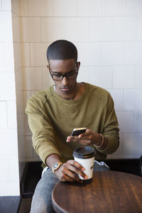 Young man in cafe with cell phone