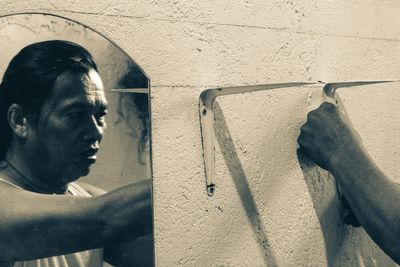 Close-up portrait of young man looking away against wall