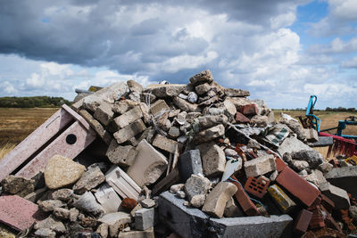 Stack of garbage on rock against sky