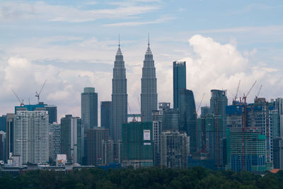 Buildings in city against cloudy sky