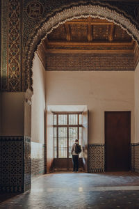 Rear view of woman walking in corridor of building