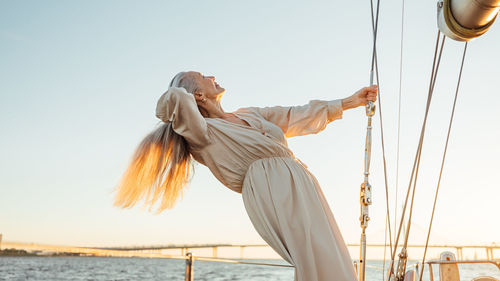 Low angle view of senior woman against sky