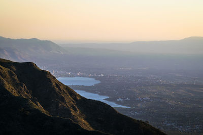 Scenic view of sea and mountains against clear sky