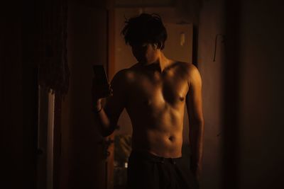 Young man standing against wall