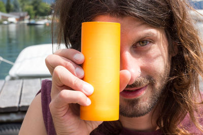 Young man holding a drink in a blank can with copy space