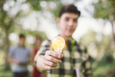 Close-up of man holding light bulb