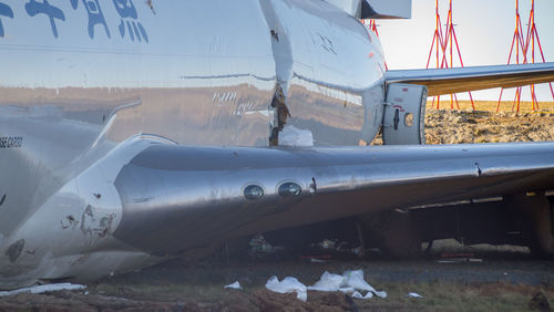 Close-up of airplane on airport runway against sky