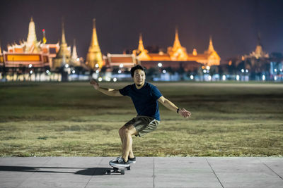 Full length of man against illuminated city at night