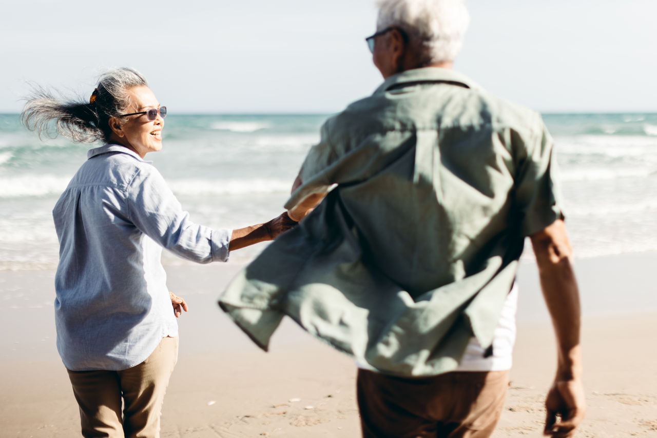 REAR VIEW OF COUPLE ON BEACH