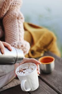 Midsection of woman pouring hot chocolate in in cup