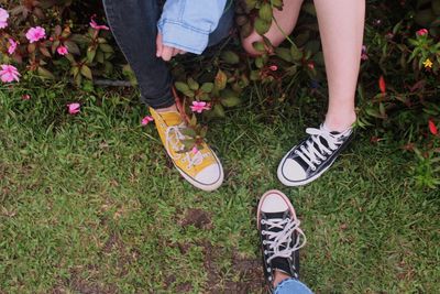 Low section of friends standing on grassy land