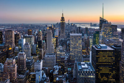 Aerial view of buildings in city at sunset