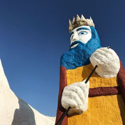 Low angle view of statue against blue sky