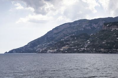 Scenic view of sea and mountains against sky