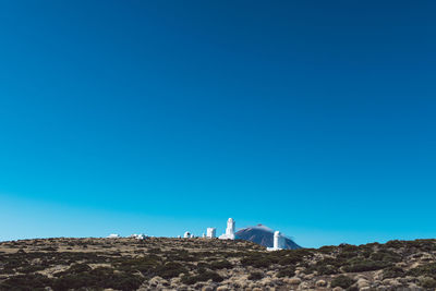 Low angle view of land against clear blue sky