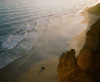 High angle view of rocks on beach during sunset