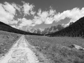 Scenic view of road by mountains against sky