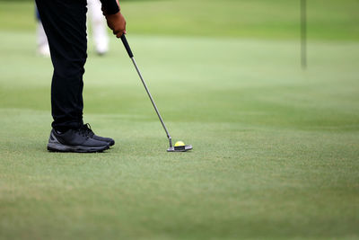 Low section of person standing on golf ball