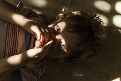 High angle portrait of boy lying on floor