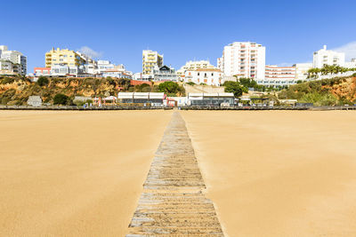 Boardwalk on beach leading to city