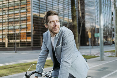 Portrait of smiling man with bicycle in city