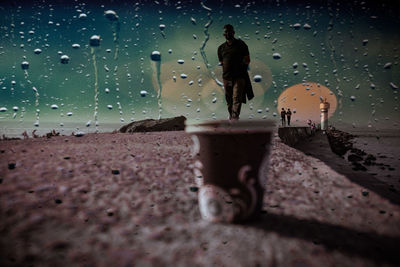 Silhouette of man standing on wet street during rainy season