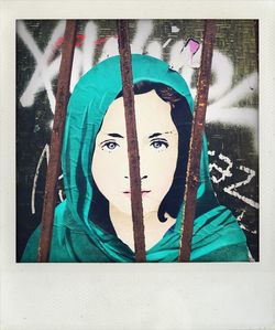 Portrait of young woman against graffiti