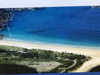 Scenic view of beach against clear blue sky