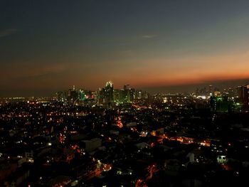 Illuminated cityscape against sky at night