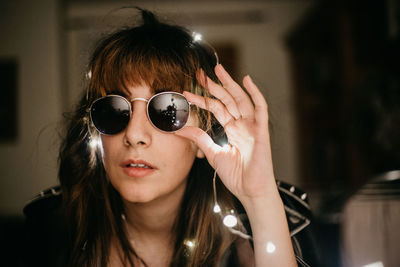 Portrait of woman wearing sunglasses at home