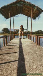 Portrait of man standing on railing against sky