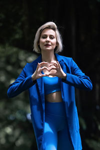 A caucasian girl sends valentine's cards to her beloved. an attractive blonde shows a heart