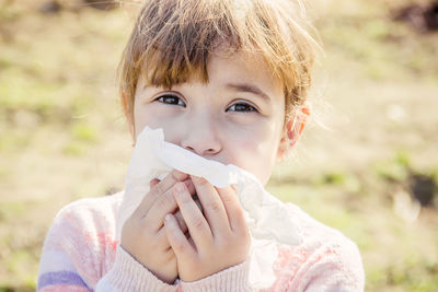 Close-up portrait of cute girl drinking water