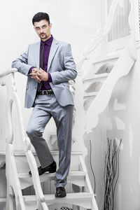 Portrait of young man standing against wall