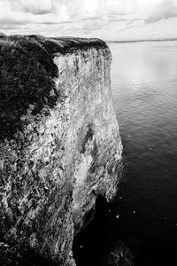 View of rock formation in sea against sky