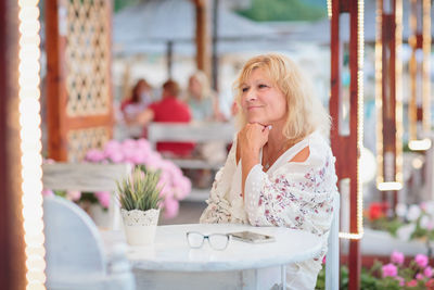 Portrait of woman sitting on the terrace of a beach cafe