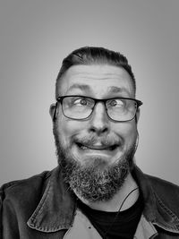 Portrait of man wearing eyeglasses against gray background