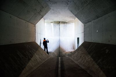 Rear view of man standing in tunnel