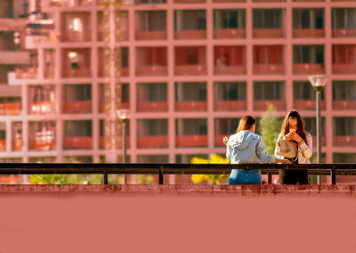 Rear view of couple sitting on bridge