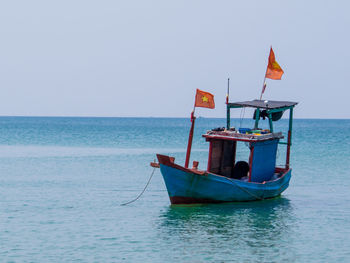 Boat moored in sea against clear sky