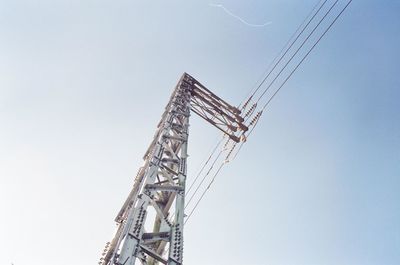 Low angle view of electricity pylon against clear sky