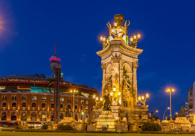 Statue in illuminated city at night